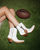 Old Gringo Boots white cowhide leather western ankle boots with contrast stitching and football charm on grass
